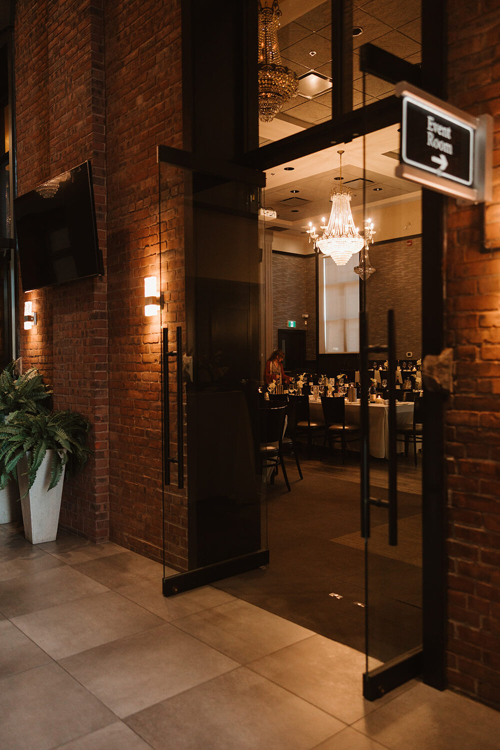 Entrance to an evening reception with brick walls and a chandelier