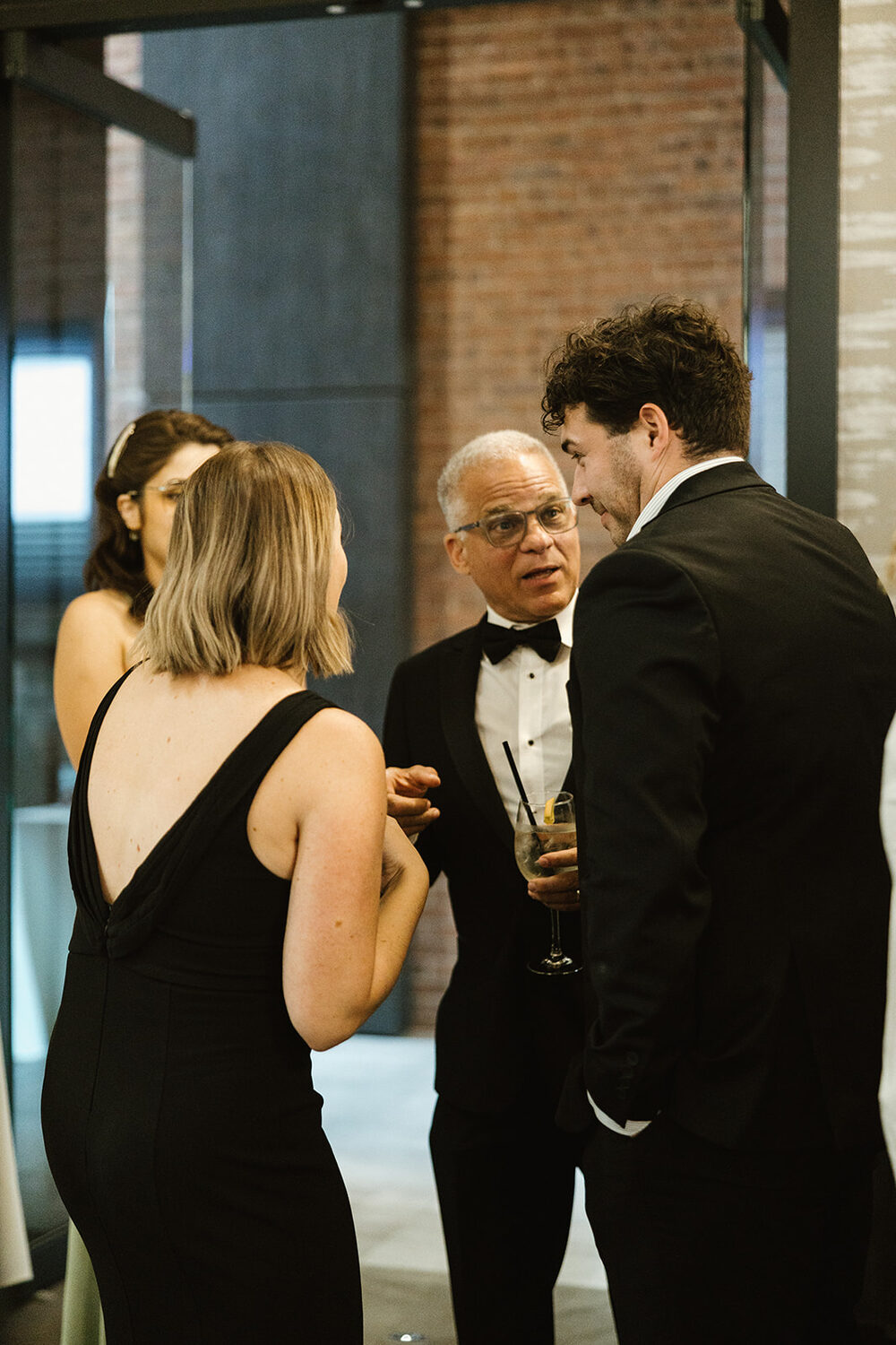 Guests in formal wear laughing together at a corporate holiday reception in Moncton